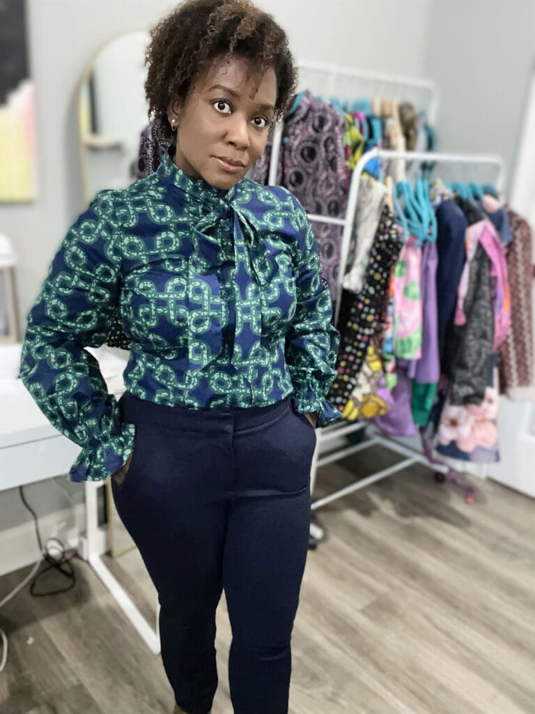 African America Woman standing wearing D'iyanu Akinyi blouse with navy pants