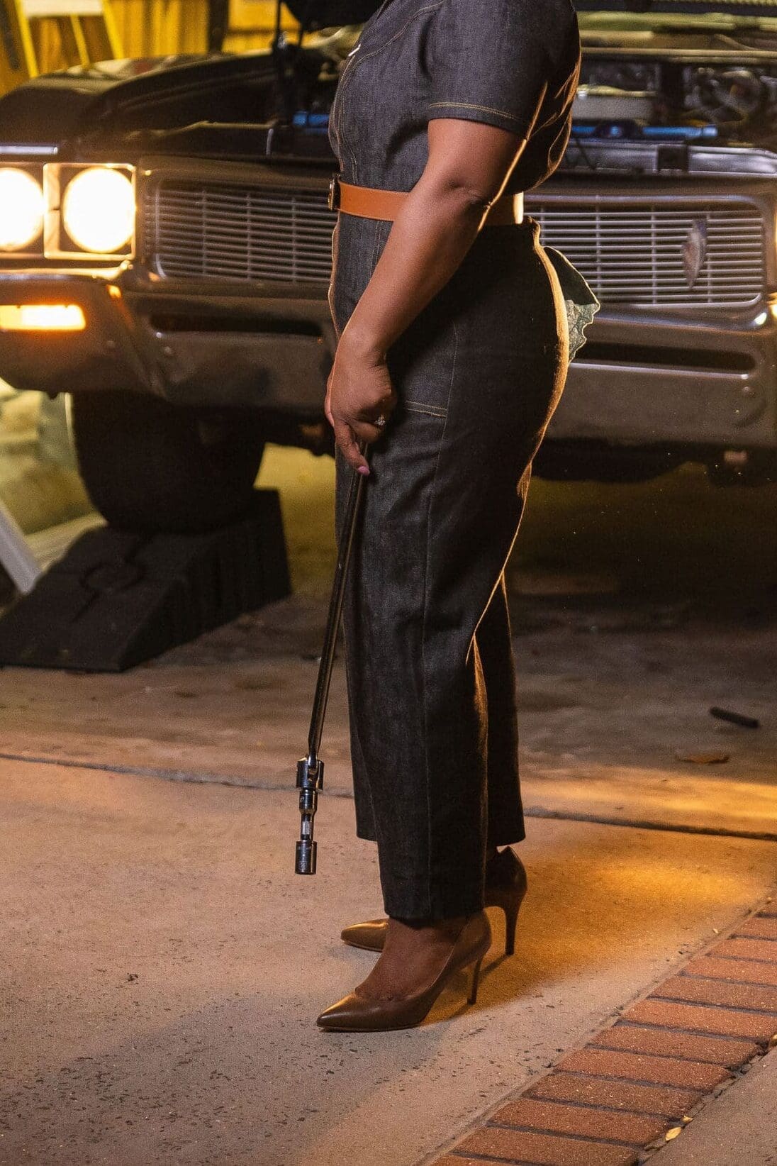 African American women holding car tool in front of car wearing McCalls7908 in the Kahmune Becky